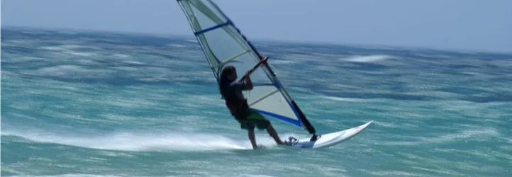 Autoptimize plugin banner showing a windsurfer riding a wave on turquoise water.